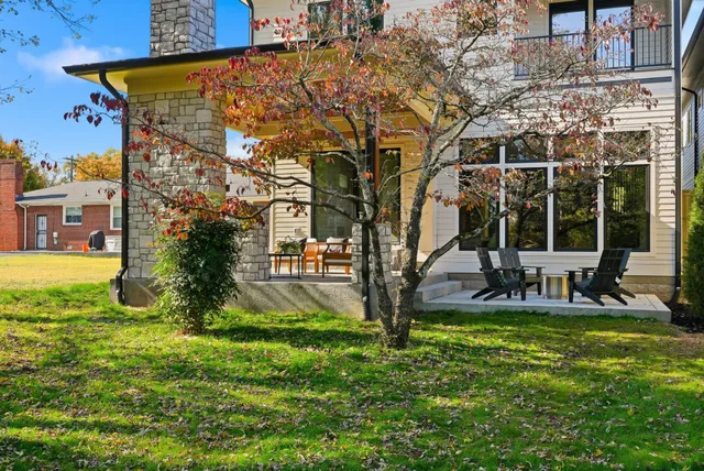 a view of house with backyard and sitting area