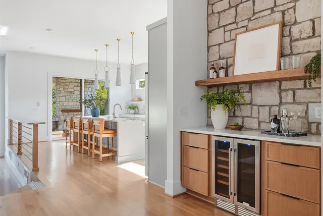 a kitchen with stainless steel appliances granite countertop a stove and a dining table with wooden floor