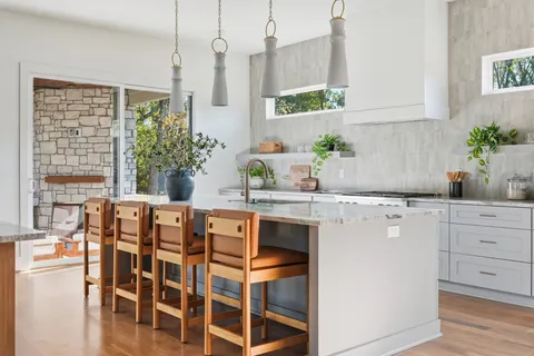 a kitchen with granite countertop a sink and a white cabinets