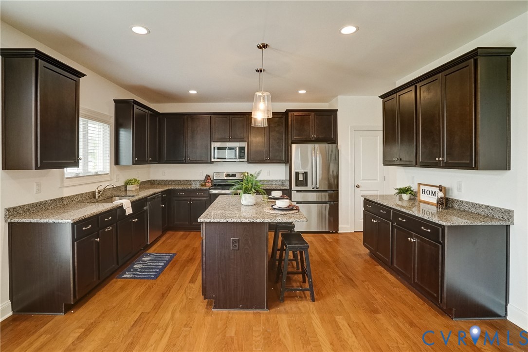 119 Thorncliff Road Ashland, VA 23005 - Photo 4 of 30 a kitchen with stainless steel appliances granite countertop a stove top oven a sink dishwasher a refrigerator and a dining table with wooden floor