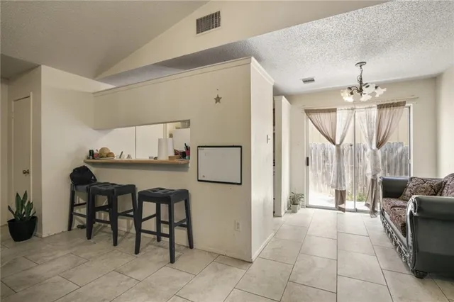 a room with stainless steel appliances a dining table and chairs