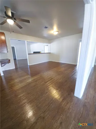 a view of empty room with wooden floor