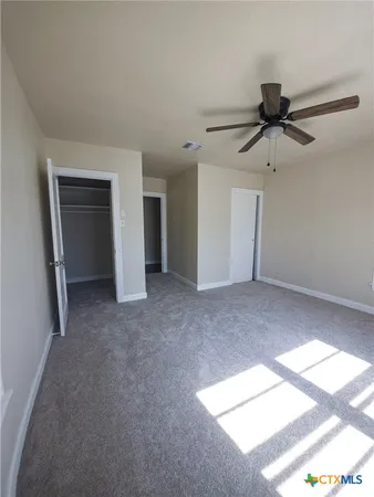 a view of a livingroom with a chandelier fan and a window