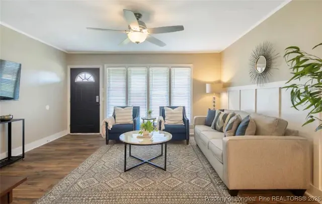 a living room with furniture and a wooden floor
