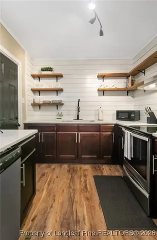 a kitchen with stainless steel appliances kitchen island granite countertop a stove and a sink