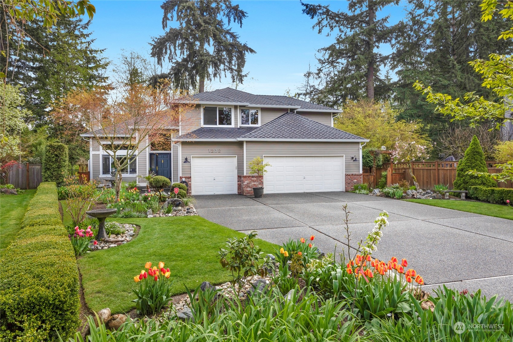 1232 144th Place Southeast Mill Creek, WA 98012 - Photo 1 of 39 a front view of a house with a garden and trees