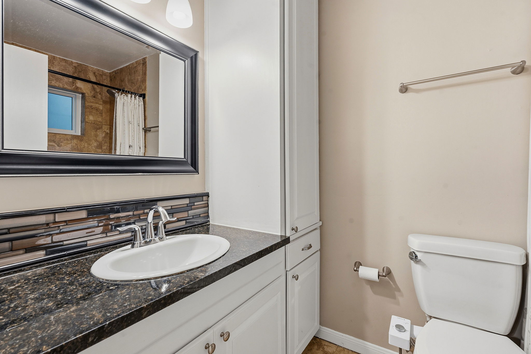 1210 Windsor Road, Unit 104 Austin, TX 78703 - Photo 17 of 27 Bathroom featuring a dark granite countertop with an undermount sink, white cabinetry with silver hardware, and a mosaic tile backsplash
