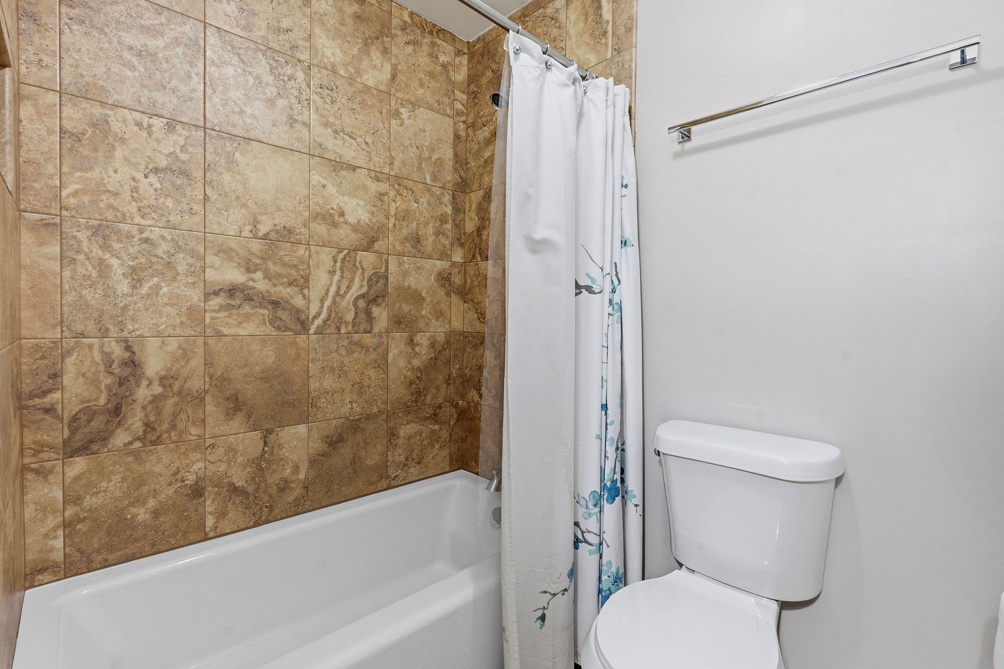 1210 Windsor Road, Unit 104 Austin, TX 78703 - Photo 22 of 27 Bathroom featuring a white tub, natural stone-look wall tiles, and white walls