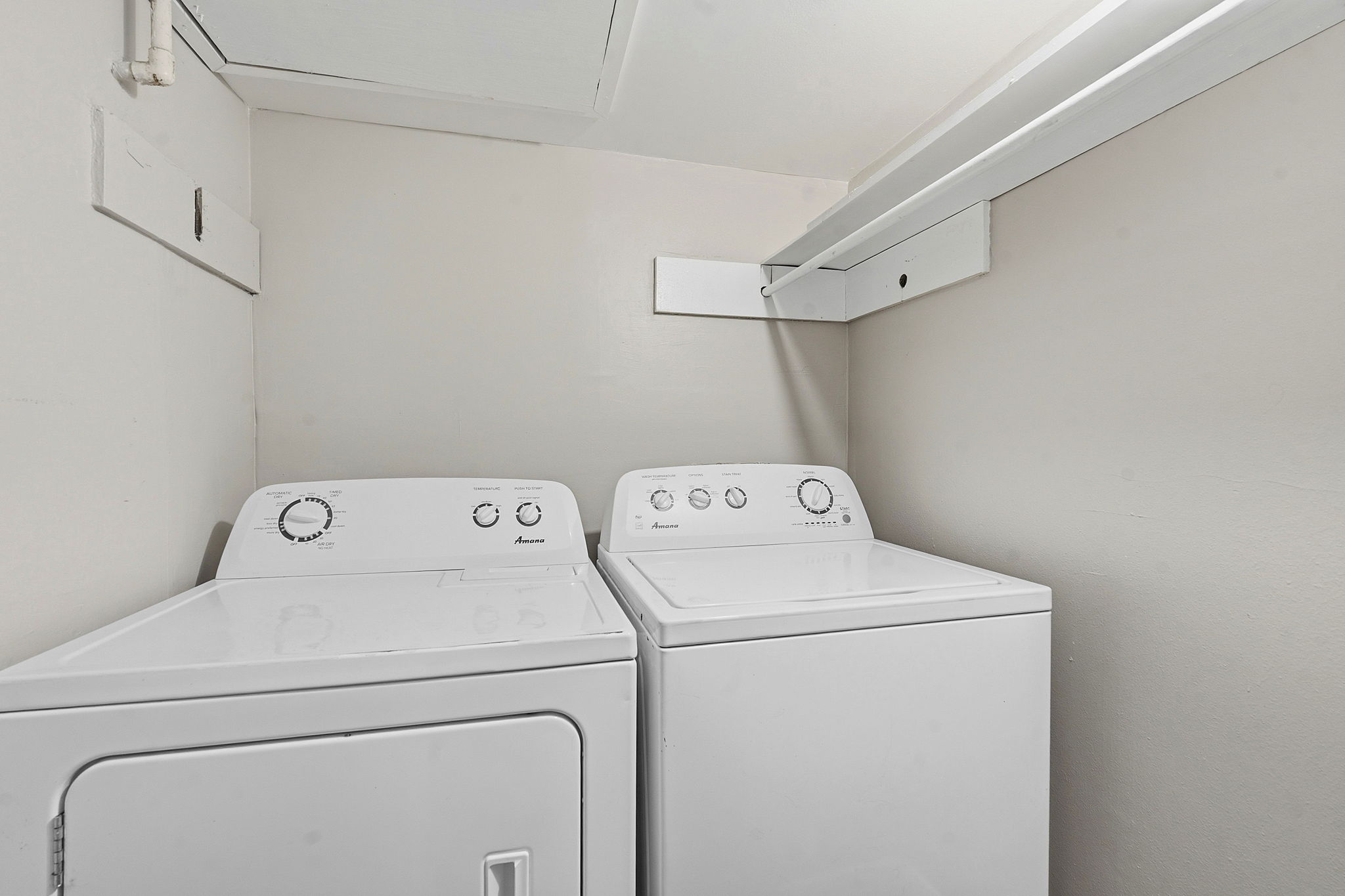 1210 Windsor Road, Unit 104 Austin, TX 78703 - Photo 23 of 27 Dedicated laundry area featuring a washer and dryer set, neutral wall color, and overhead shelving for storage