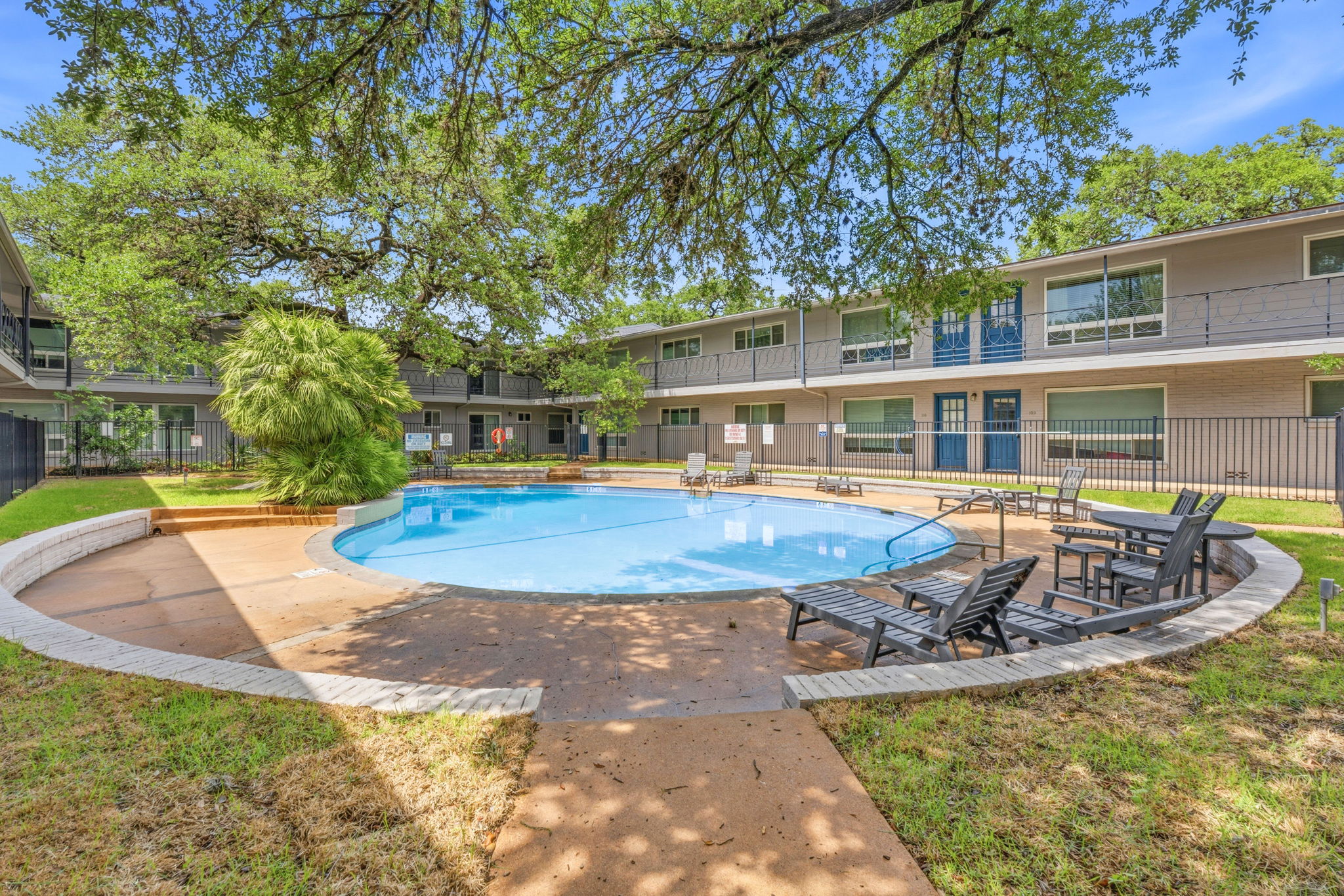 1210 Windsor Road, Unit 104 Austin, TX 78703 - Photo 25 of 27 Central swimming pool with surrounding patio, integrated lounge seating, and perimeter landscaping
