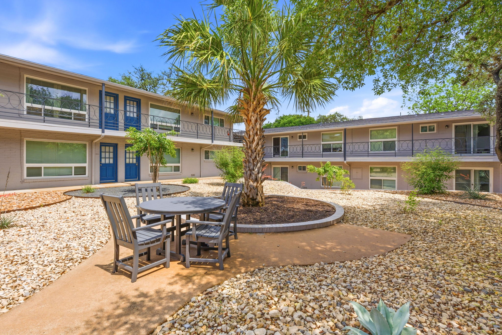 1210 Windsor Road, Unit 104 Austin, TX 78703 - Photo 26 of 27 Courtyard featuring a mature palm tree and rock landscaping