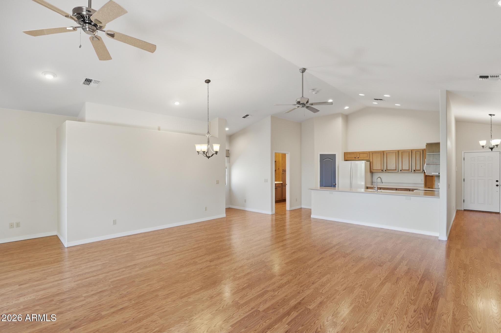 408 East Phoenix Street Payson, AZ 85541 - Photo 8 of 35 an empty room with wooden floor a ceiling fan and kitchen view
