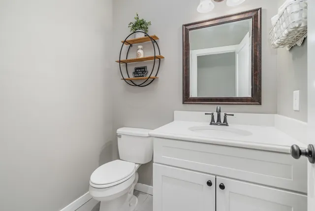 a bathroom with a toilet a sink and mirror
