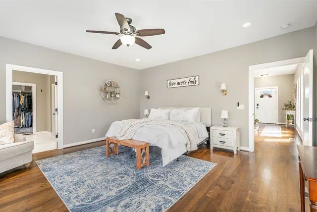 a bedroom with a bed rug and wooden floor