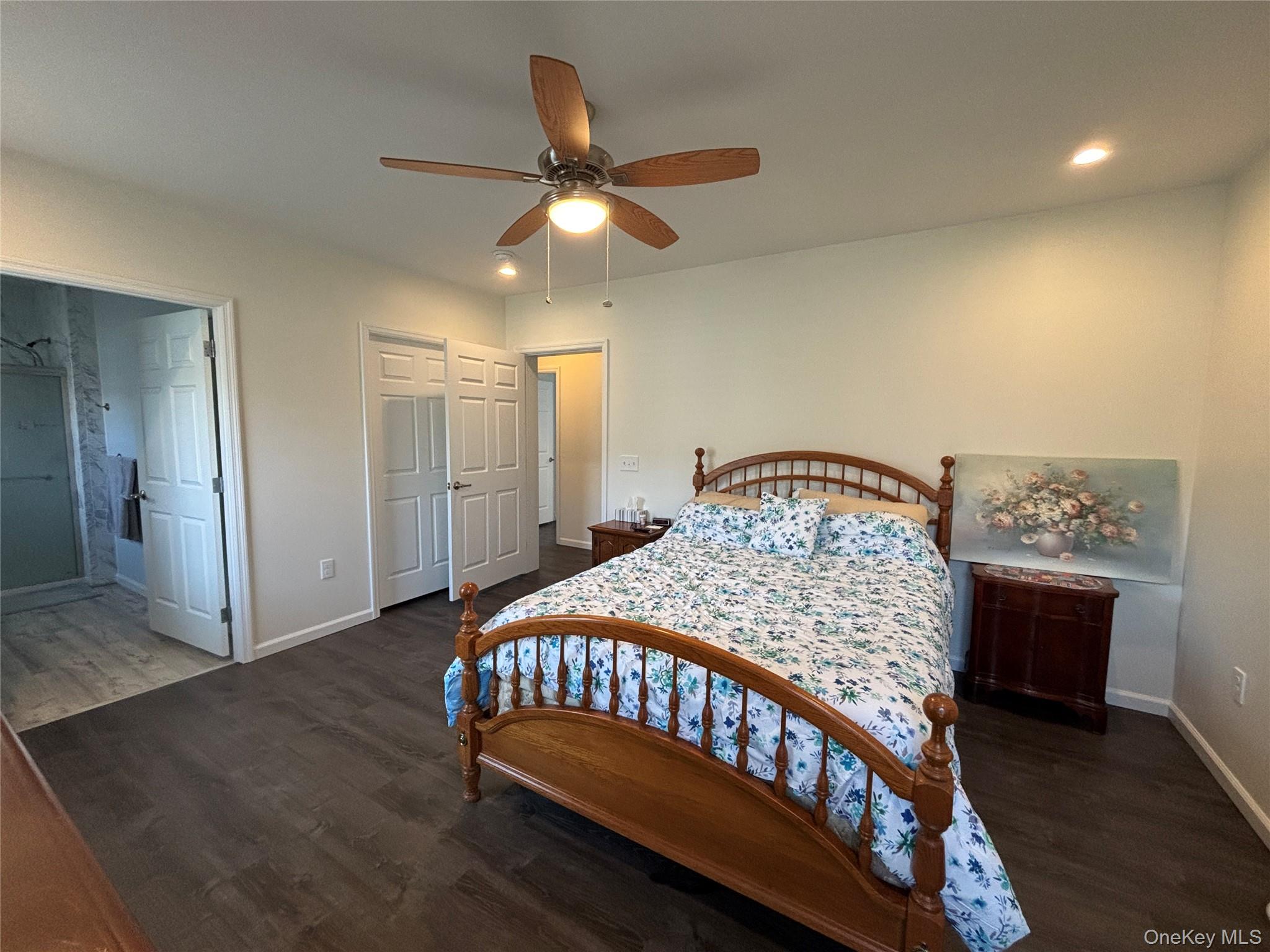 1661 Old Country Road, Unit 563 Riverhead, NY 11901 - Photo 29 of 43 a bedroom with a bed and a chandelier