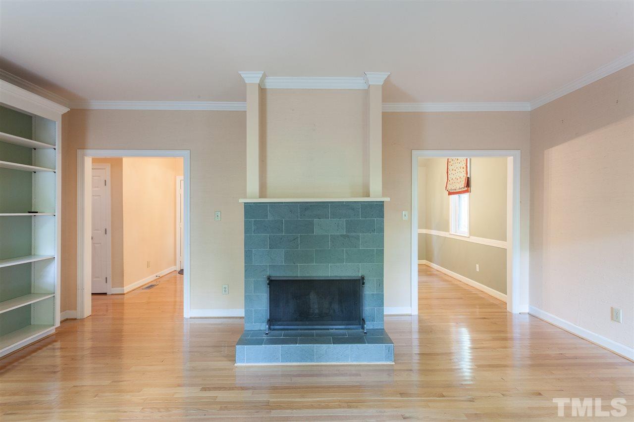 1711 Falls Church Road Raleigh, NC 27609 - Photo 14 of 29 a living room with a fireplace and wooden floor