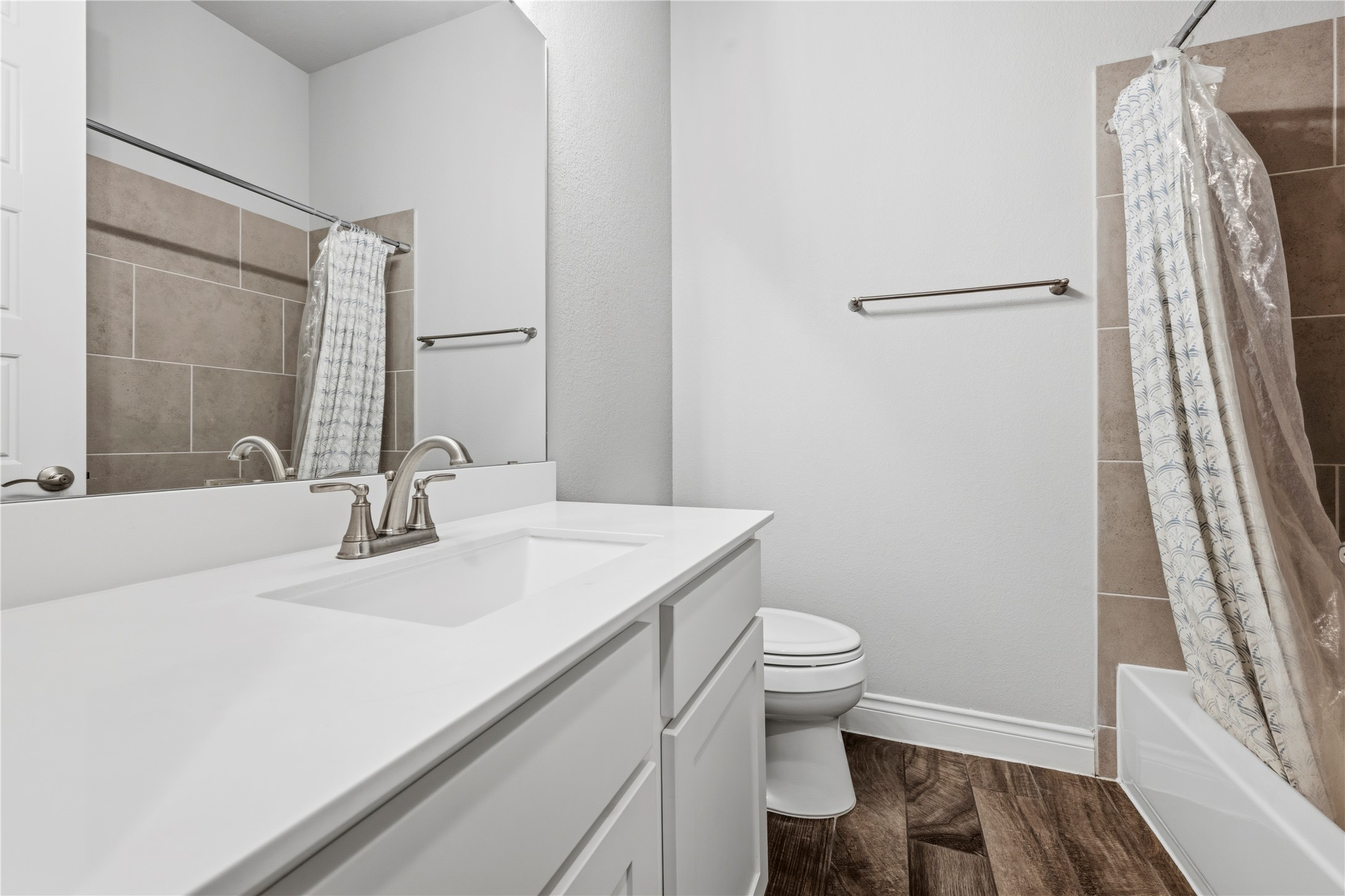 140 Catani Loop Georgetown, TX 78628 - Photo 7 of 36 A well-appointed bathroom features a pristine white vanity and rich wood-look flooring.
