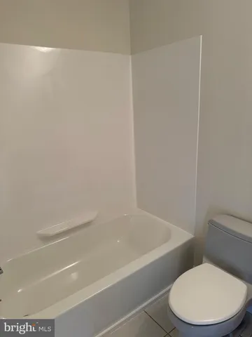 a white toilet sitting next to a bath tub