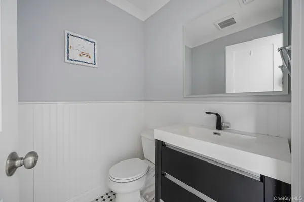 a bathroom with a sink mirror and toilet