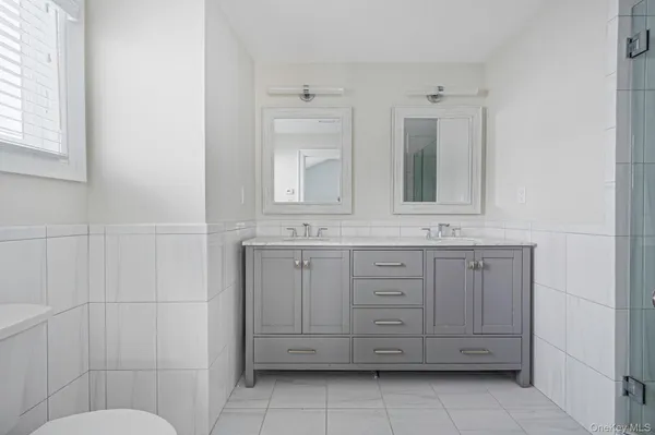 a bathroom with a granite countertop sink mirror and shower