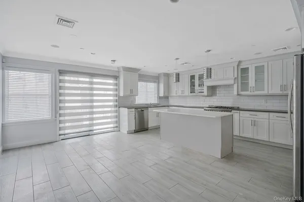 a kitchen with stainless steel appliances cabinets and a window