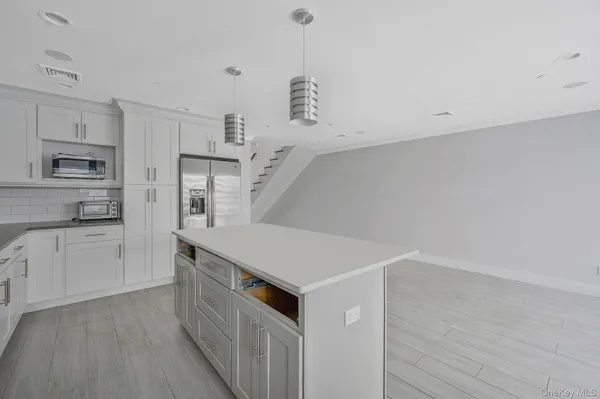 a kitchen with white cabinets and white appliances
