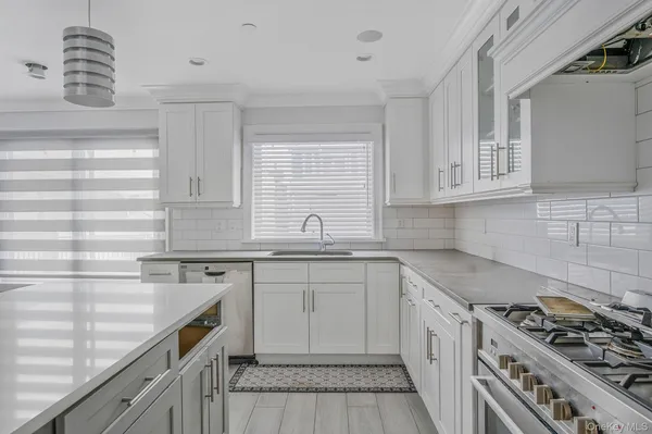 a kitchen with stainless steel appliances granite countertop a sink stove and cabinets