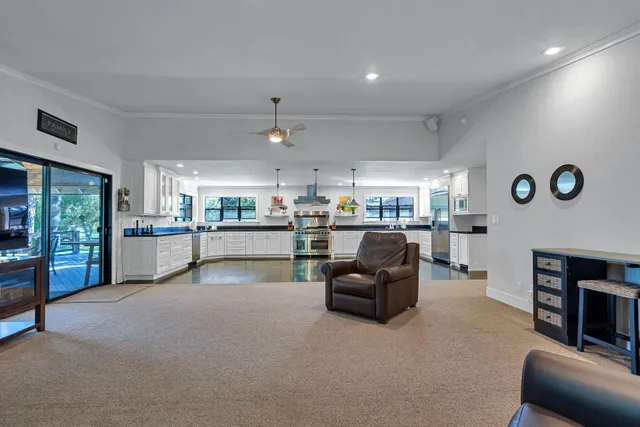 a view of an empty room with a window and a kitchen