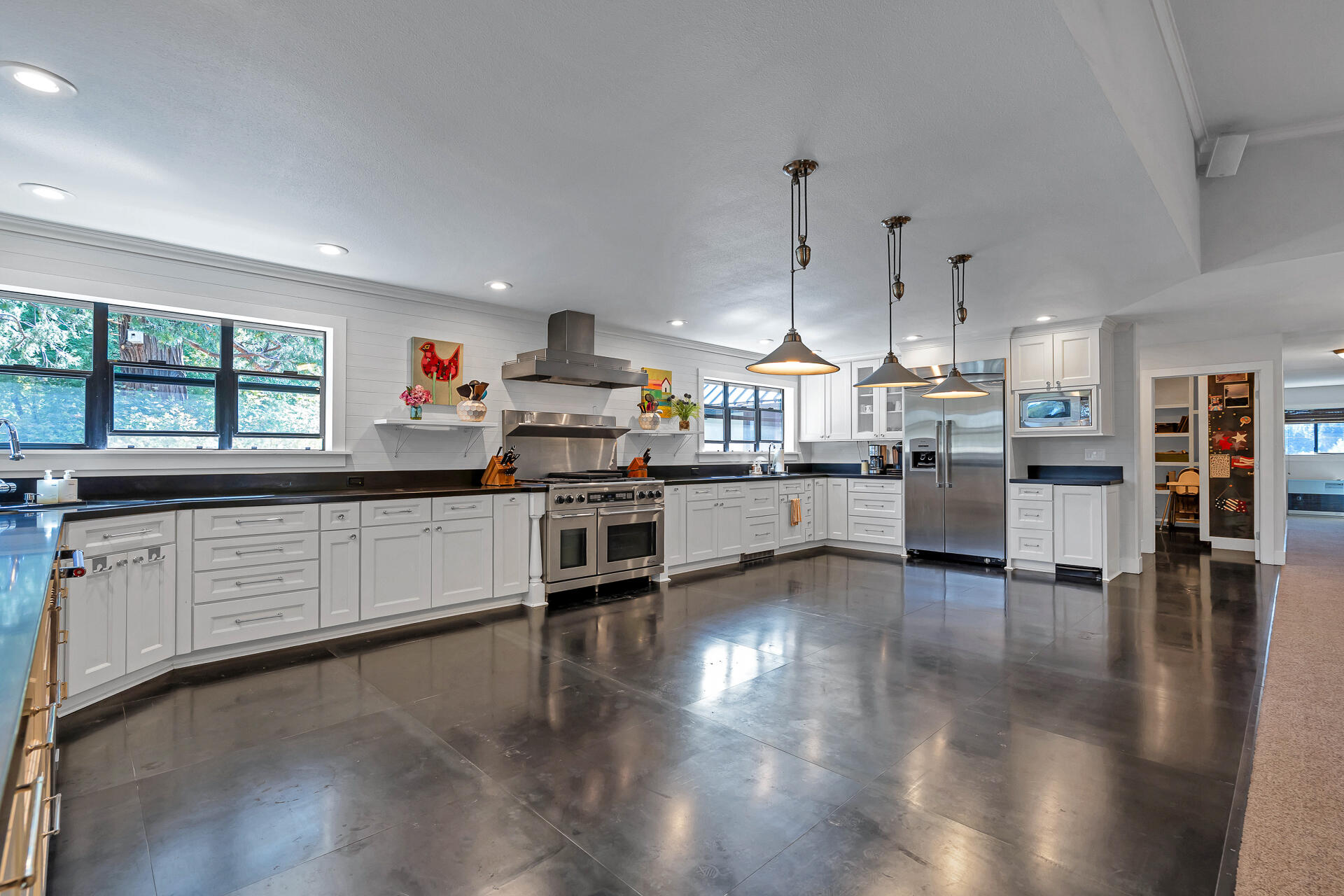 42048 Wilcox Road Hat Creek, CA 96040 - Photo 27 of 134 a kitchen with stainless steel appliances kitchen island granite countertop a stove top oven a sink a dining table and chairs with wooden floor