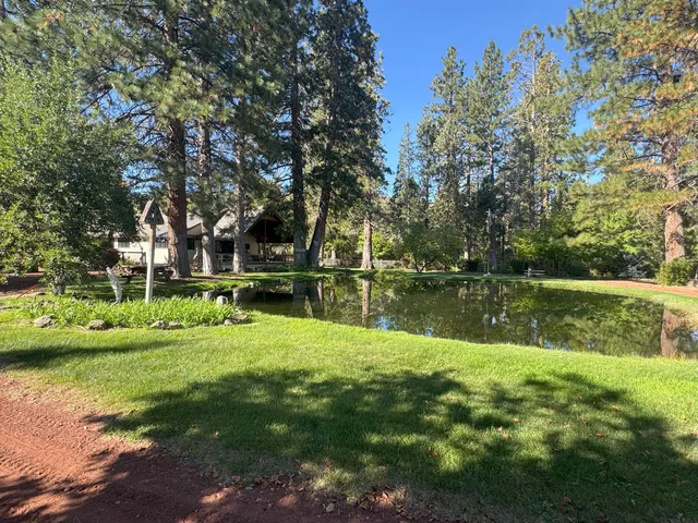 a kitchen with stainless steel appliances kitchen island granite countertop a stove top oven a sink a dining table and chairs with wooden floor