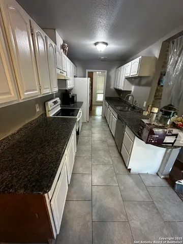 a large kitchen with stainless steel appliances granite countertop a stove and a sink