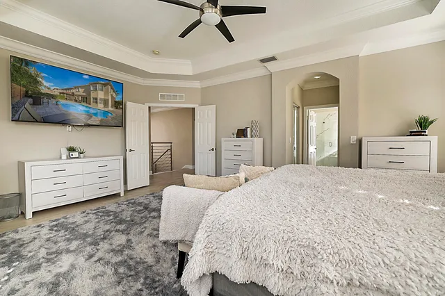 a spacious bedroom with a bed and a flat screen tv