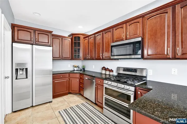 a kitchen with stainless steel appliances granite countertop a refrigerator and cabinets
