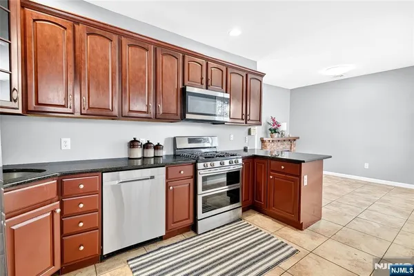 a kitchen with granite countertop cabinets stainless steel appliances and a counter space