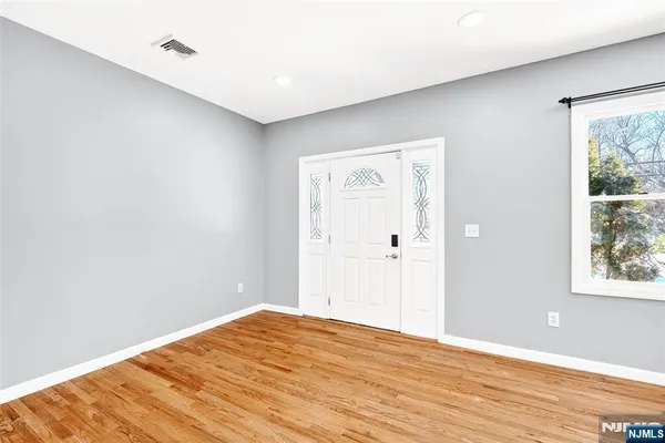 a view of empty room with wooden floor