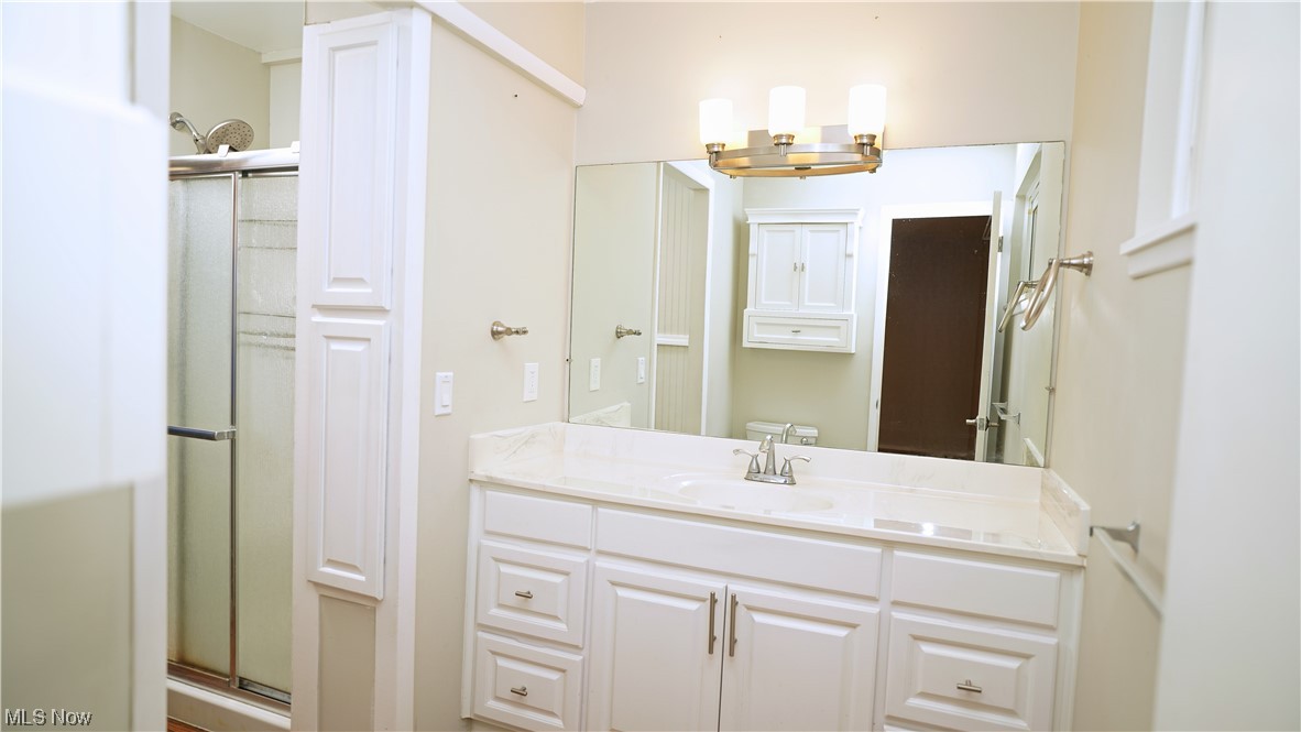 6676 Rochelle Boulevard Parma Heights, OH 44130 - Photo 13 of 21 Bathroom featuring a shower with door, toilet, and vanity