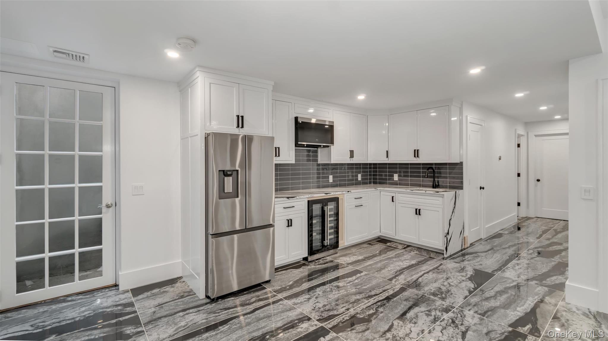 37 Wakeman Road Hampton Bays, NY 11946 - Photo 15 of 23 a kitchen with stainless steel appliances a refrigerator sink and cabinets