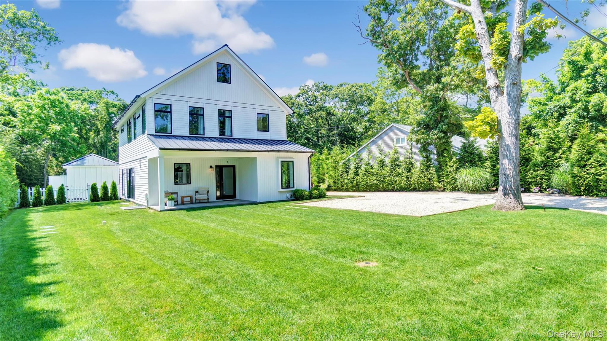 37 Wakeman Road Hampton Bays, NY 11946 - Photo 3 of 23 a front view of a house with a yard and trees