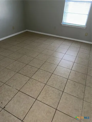 a view of a hallway with a glass door and a bathroom