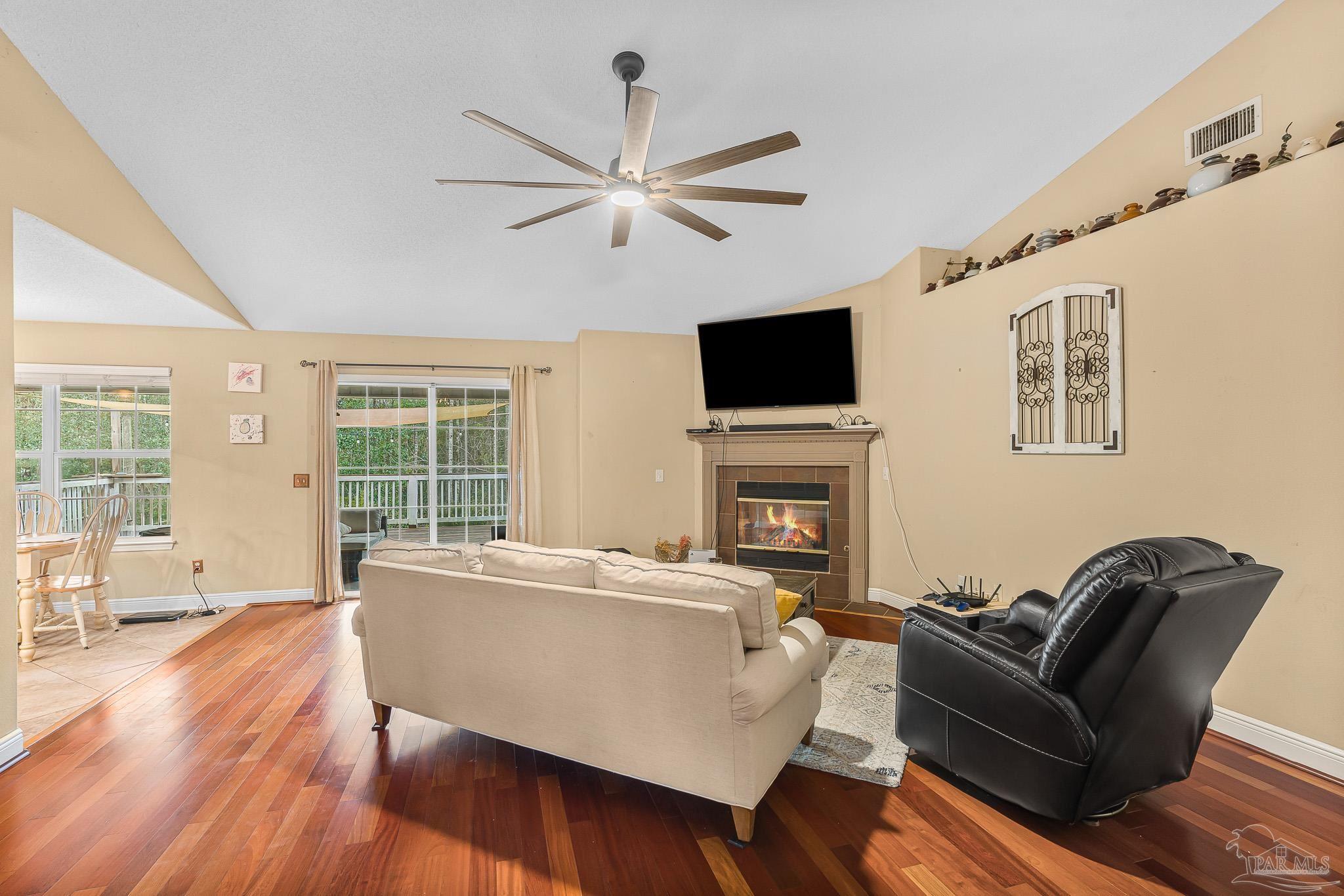 1089 Yellowstone Pass Cantonment, FL 32533 - Photo 12 of 45 a living room with furniture a fireplace a flat screen tv and wooden floor