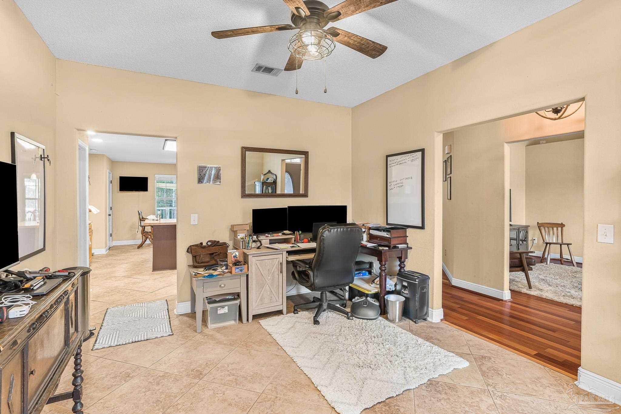1089 Yellowstone Pass Cantonment, FL 32533 - Photo 13 of 45 a living room with furniture a chandelier and a flat screen tv