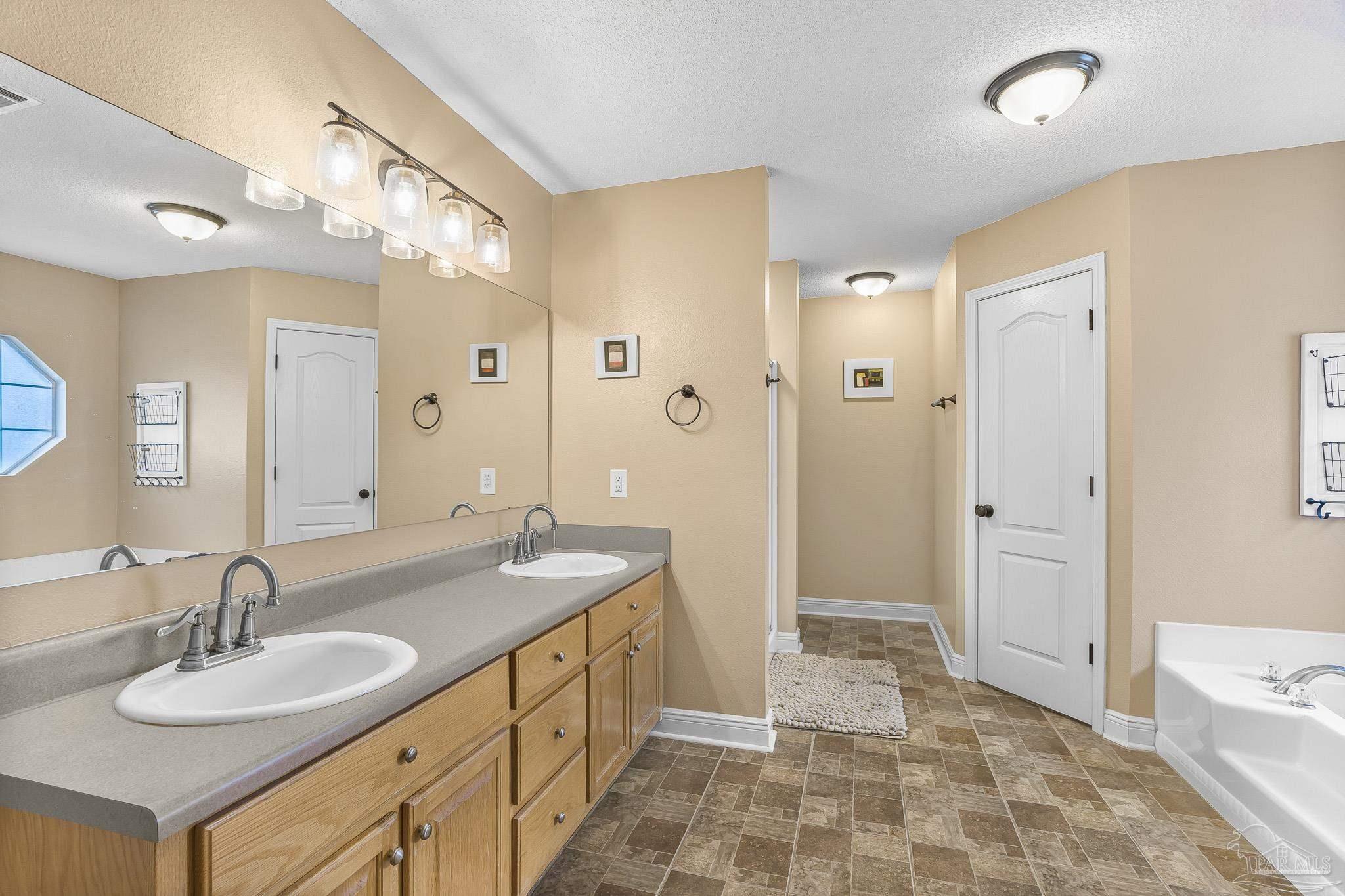 1089 Yellowstone Pass Cantonment, FL 32533 - Photo 21 of 45 a spacious bathroom with a double vanity sink mirror and shower