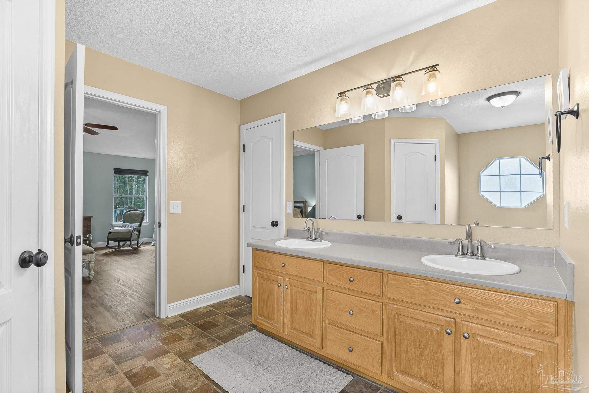 1089 Yellowstone Pass Cantonment, FL 32533 - Photo 24 of 45 a spacious bathroom with a double vanity sink shower and a mirror