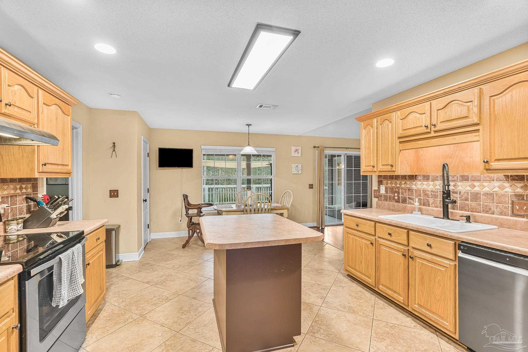 1089 Yellowstone Pass Cantonment, FL 32533 - Photo 5 of 45 a large kitchen with kitchen island a large counter top space a sink a refrigerator and cabinets