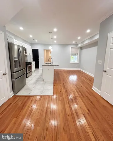 a view of a kitchen with wooden floors and stainless steel appliances