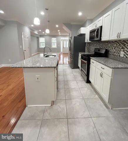 a kitchen with stainless steel appliances granite countertop a sink and cabinets