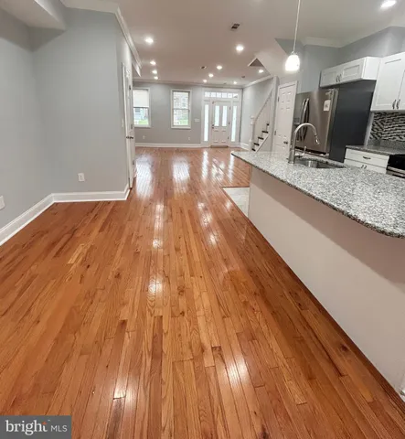 a view of kitchen with granite countertop window and wooden floor