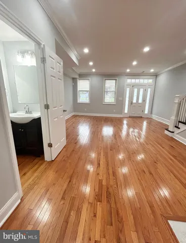 a view of an empty room and a kitchen