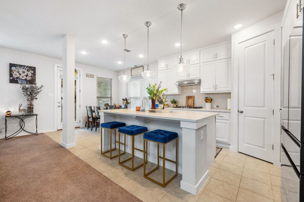 128 Three Oaks Lane Georgetown, TX 78628 - Photo 8 of 40 a kitchen with kitchen island granite countertop a sink a center island and appliances