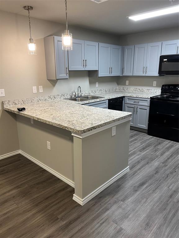 a kitchen with granite countertop wooden floors and white cabinets